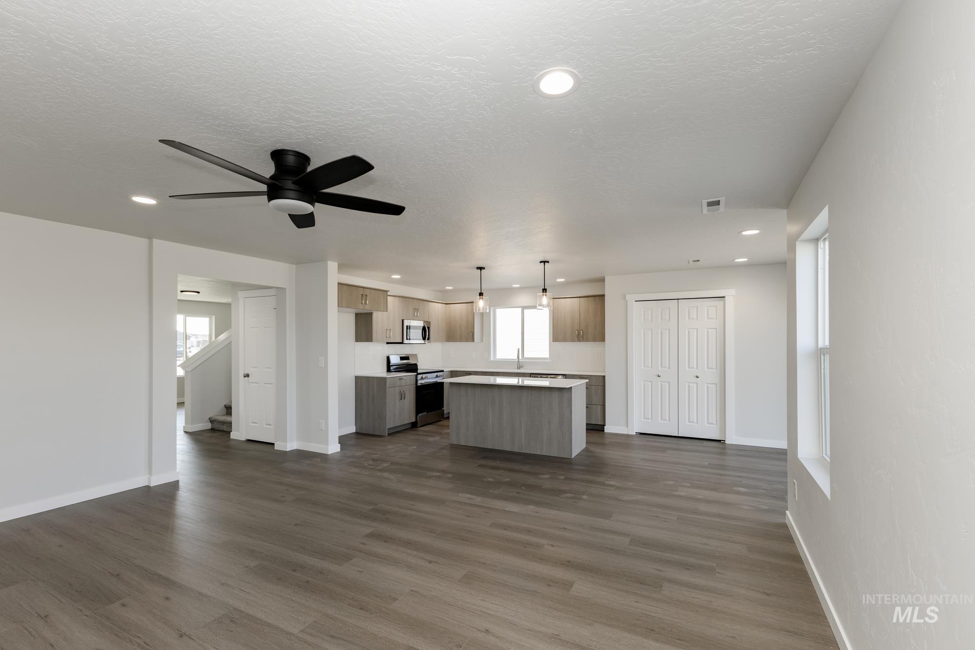Kitchen with open floor plan, a center island, light countertops, recessed lighting, and decorative light fixtures