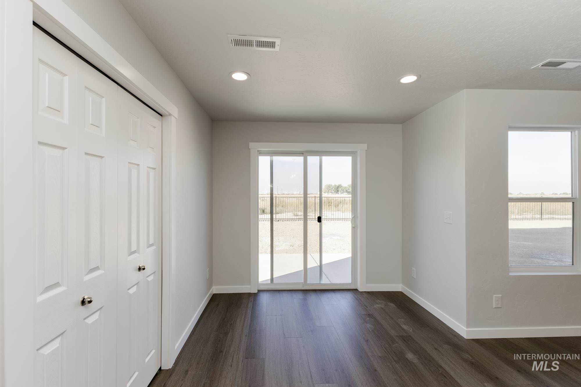 Unfurnished bedroom with access to exterior, dark wood-type flooring, recessed lighting, and a closet