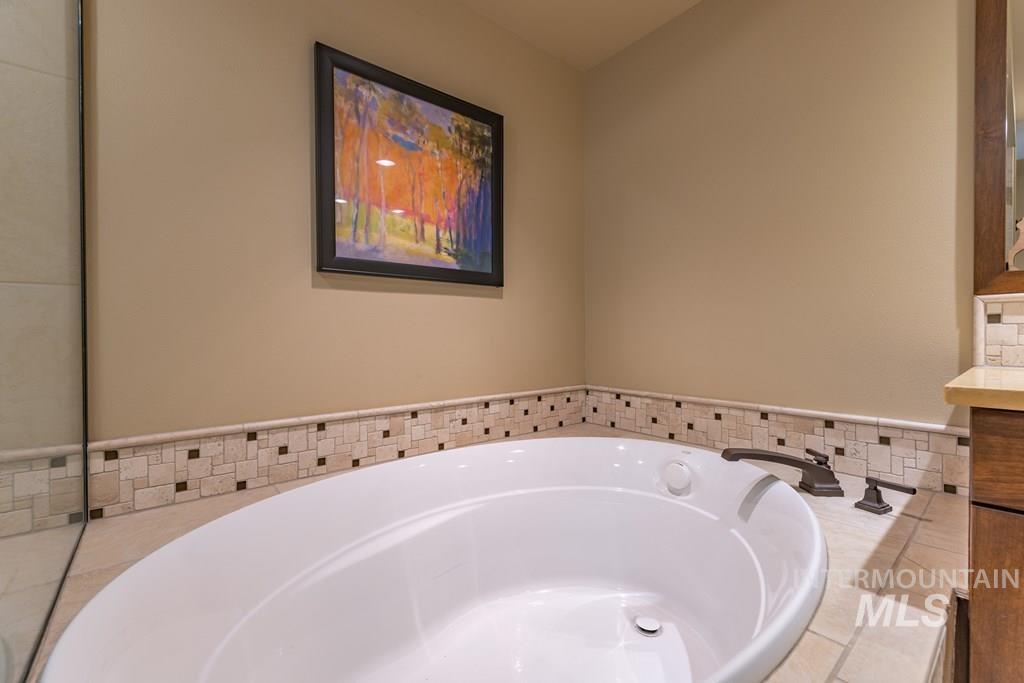 Full bath featuring vanity and a bath