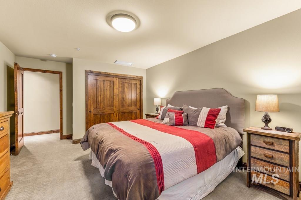 Bedroom with light carpet and a closet