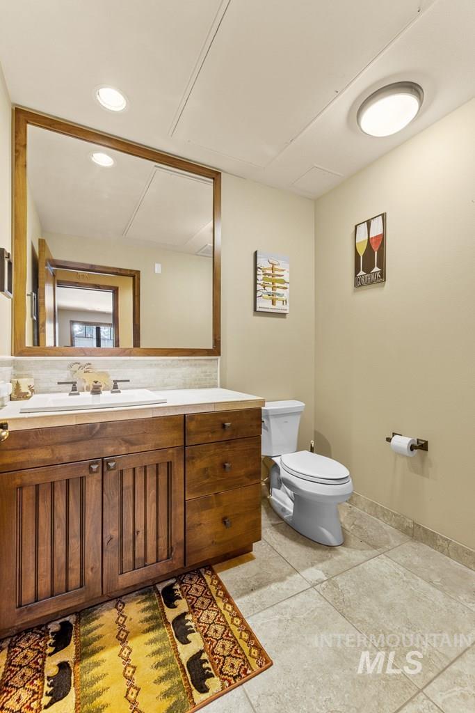 Half bath featuring vanity, recessed lighting, and light tile patterned floors