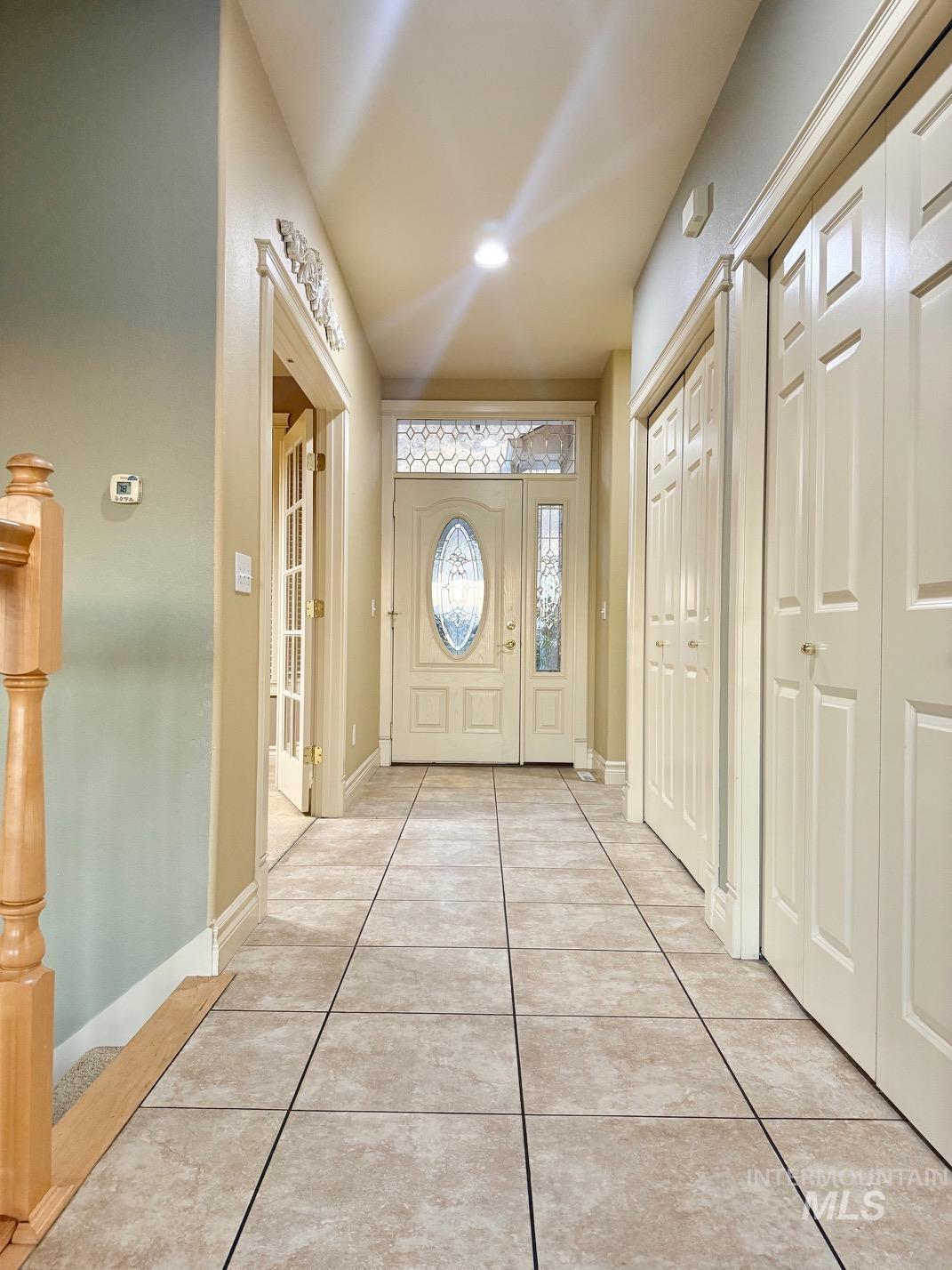 Entrance foyer featuring light tile patterned flooring and baseboards