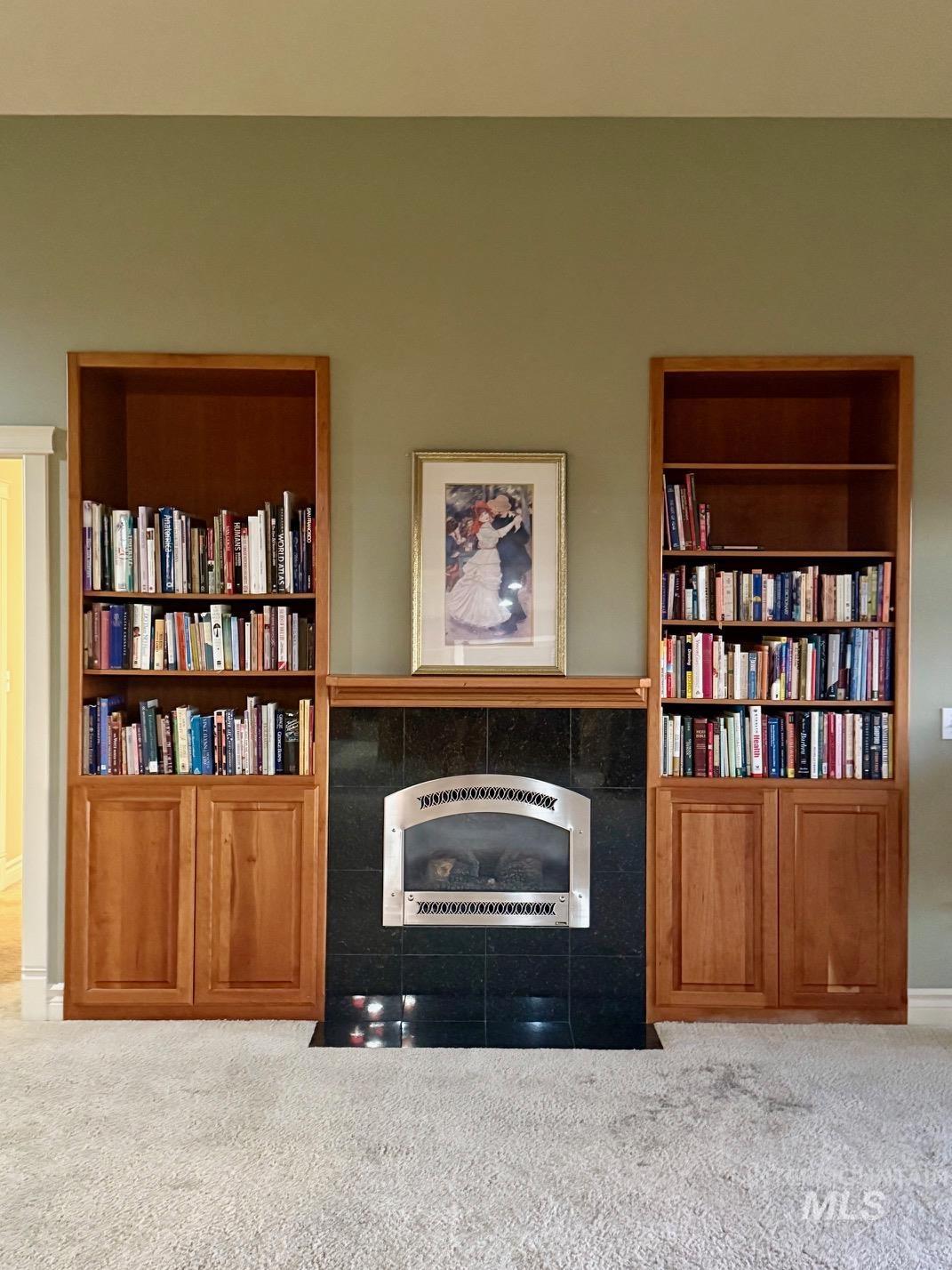 Detailed view of a tile fireplace, carpet floors, and heating unit