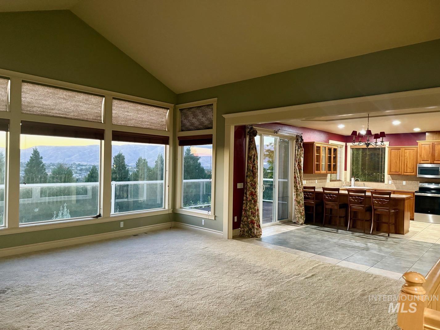 Kitchen featuring glass insert cabinets, a kitchen bar, light countertops, a mountain view, and stainless steel appliances