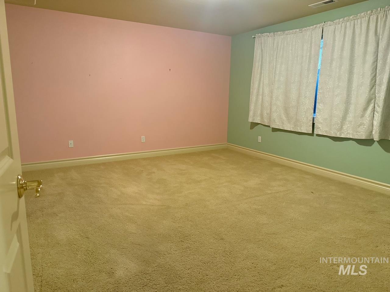 Spare room with carpet and baseboards