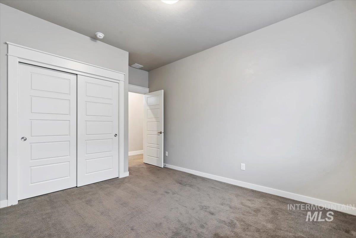 Unfurnished bedroom featuring a closet and carpet floors