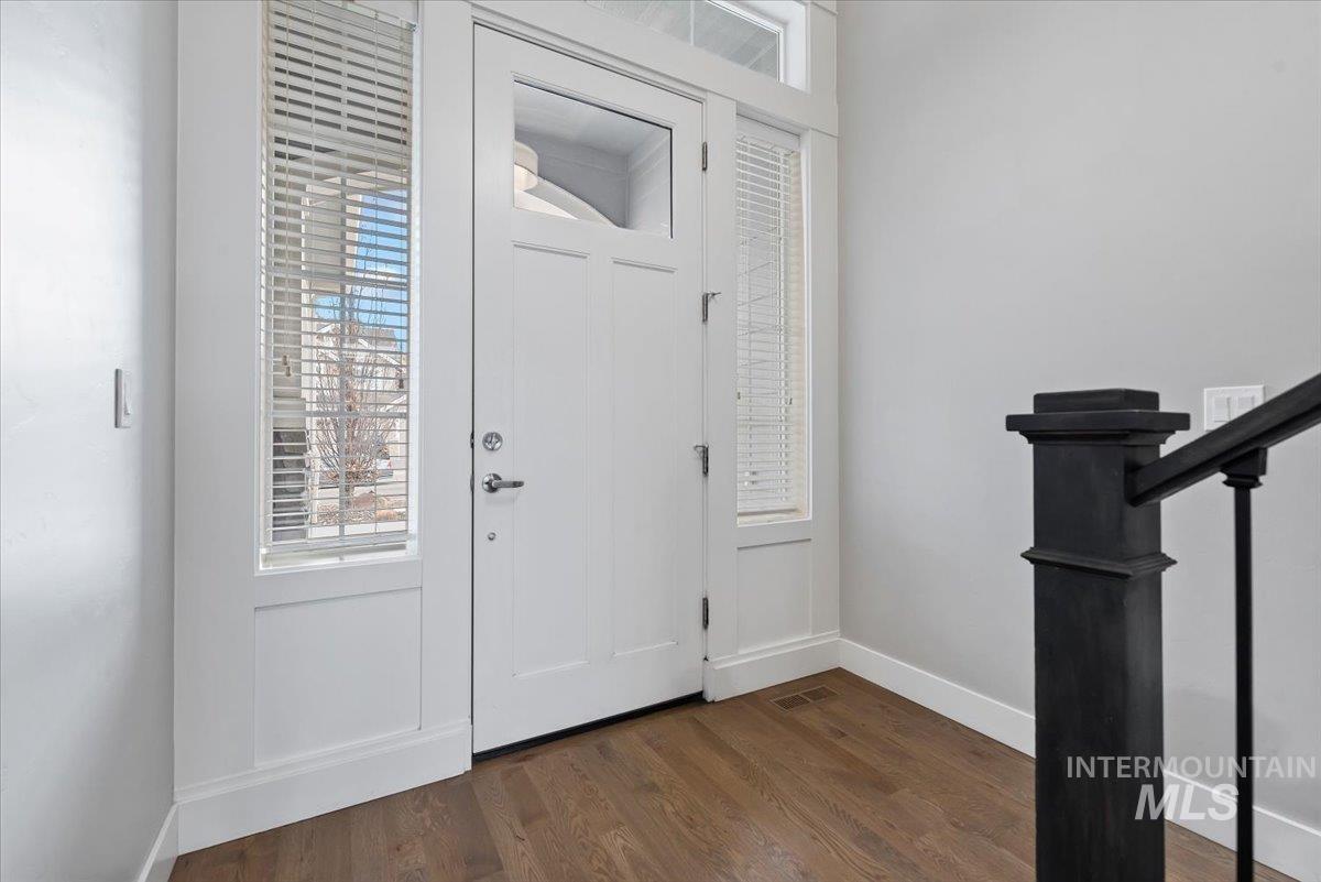 Entryway with stairway, dark wood-style flooring, and plenty of natural light