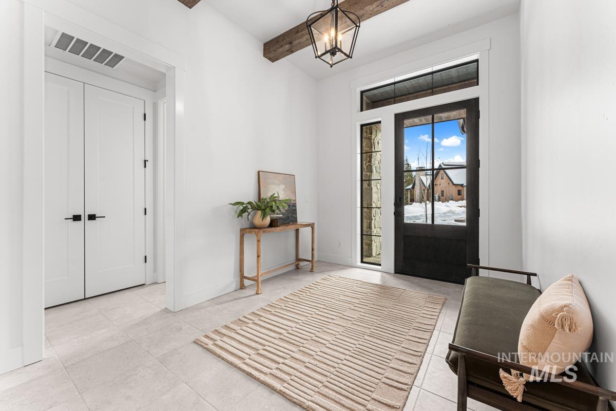 Foyer entrance with a chandelier and beam ceiling