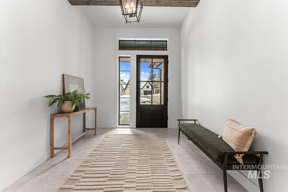Foyer entrance with baseboards and suspended lighting