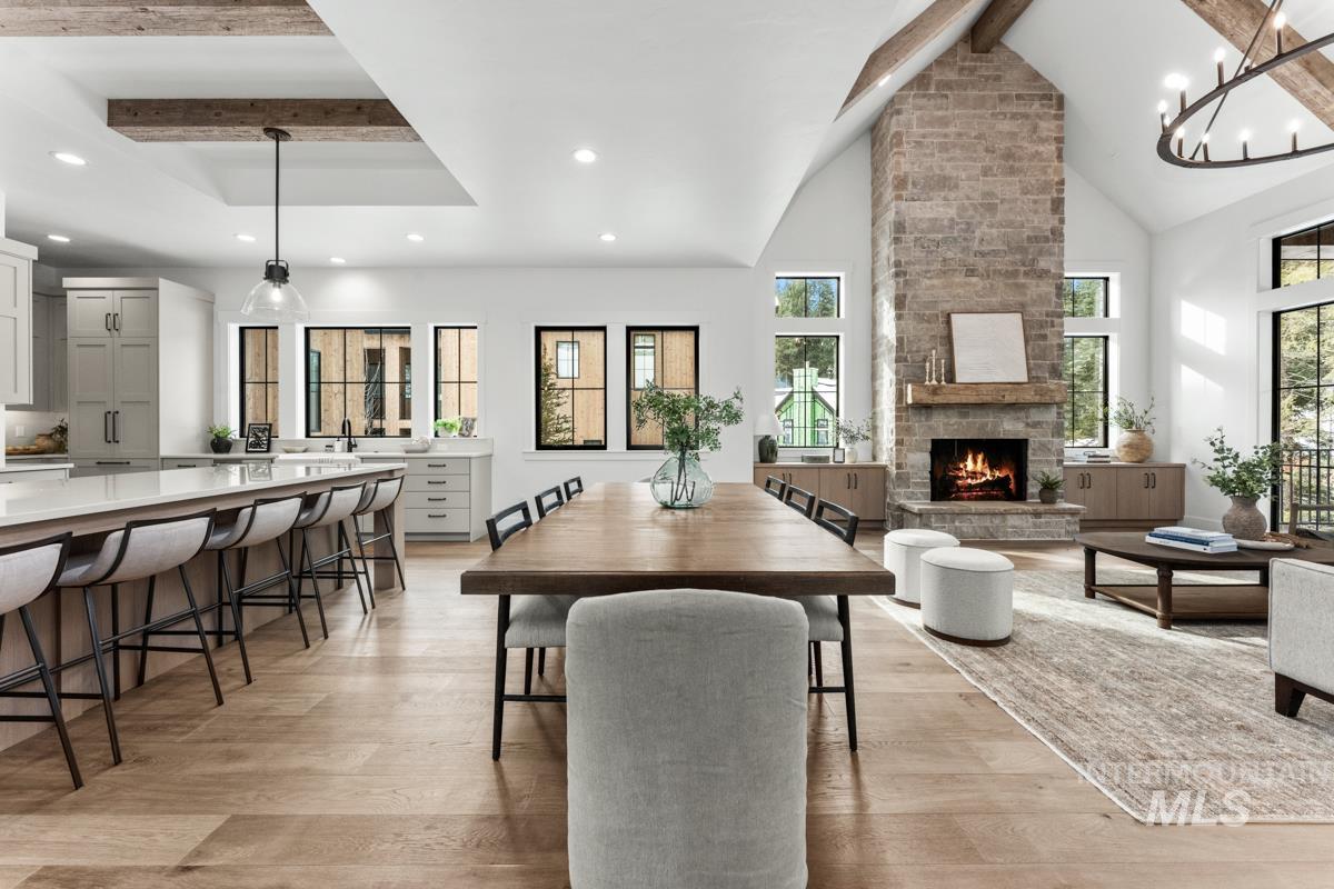 Dining area featuring light wood finished floors, a fireplace, and hanging lights