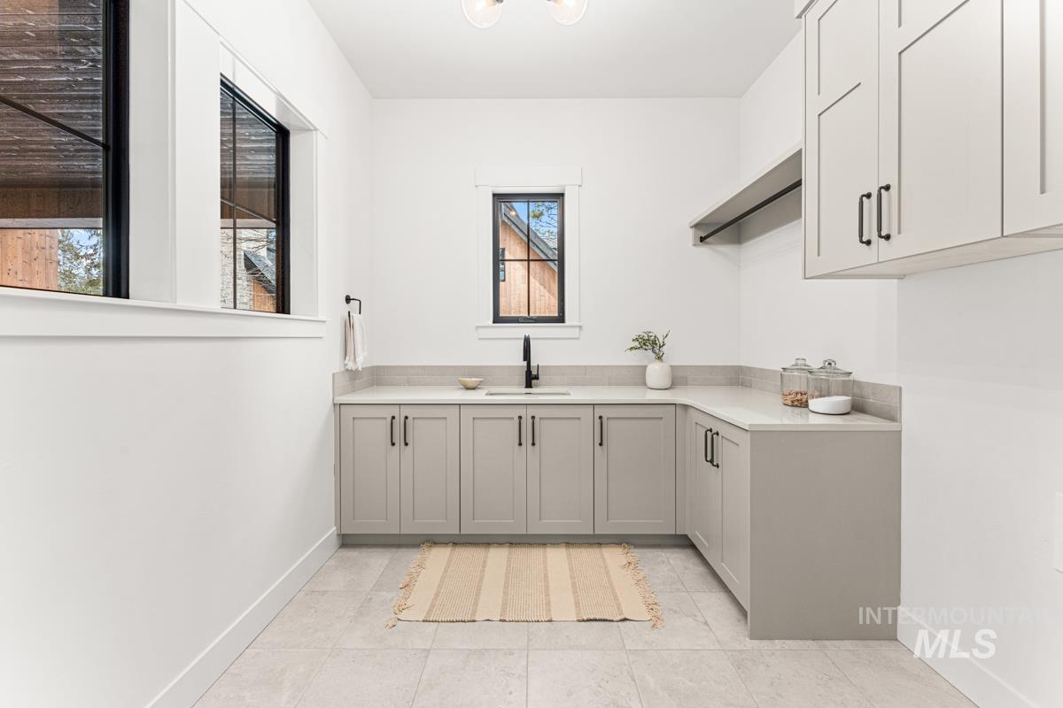 Laundry room featuring baseboards and light tile patterned flooring