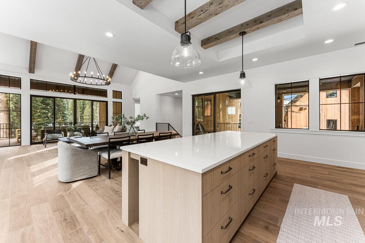 Kitchen featuring beamed ceiling, modern cabinets, a center island, light wood finished floors, and healthy amount of natural light