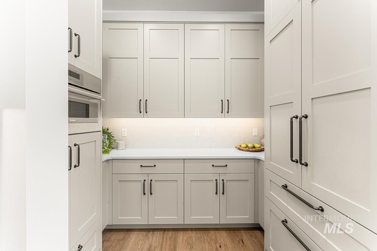 Kitchen featuring light wood-style floors, light stone countertops, and stainless steel oven