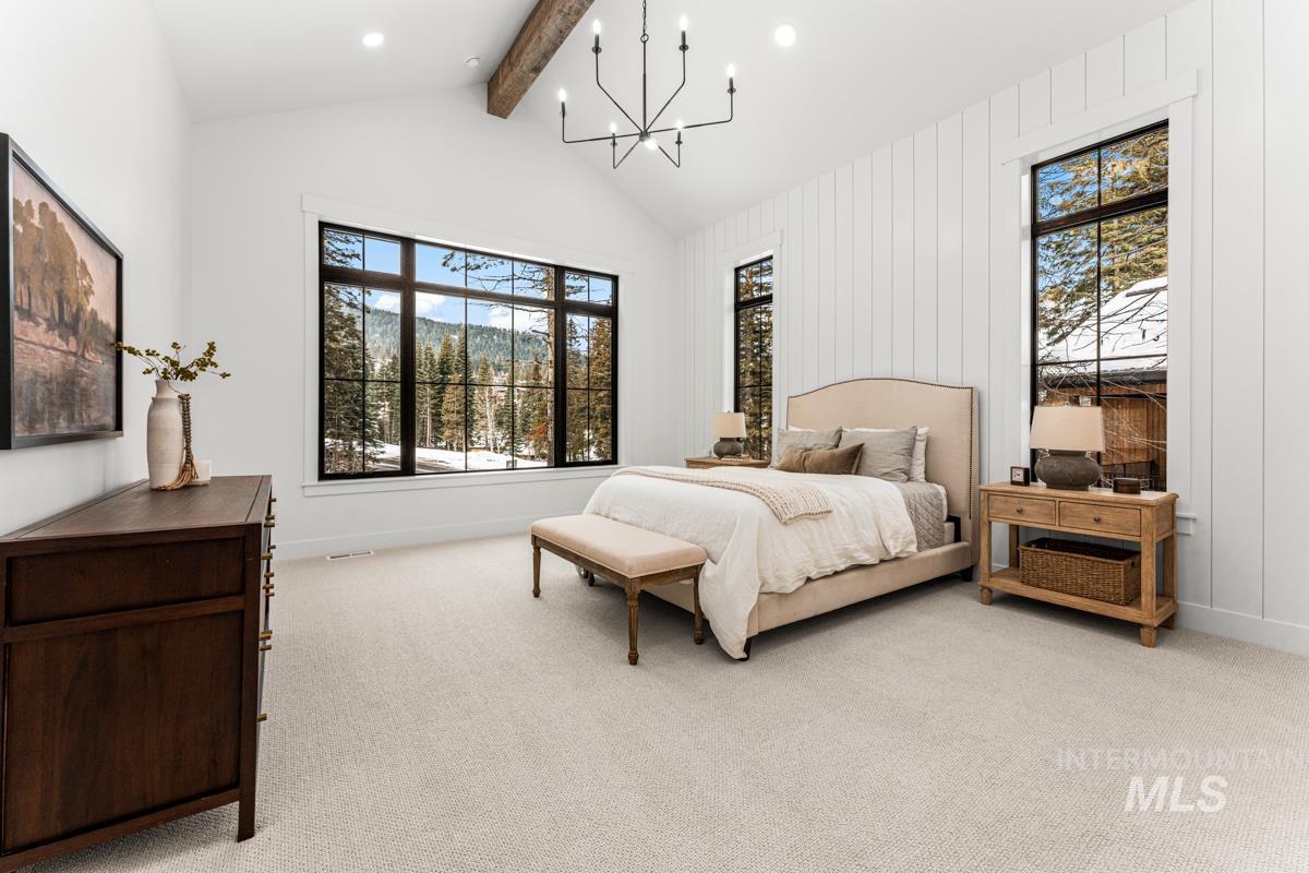 Bedroom with a chandelier and light carpet