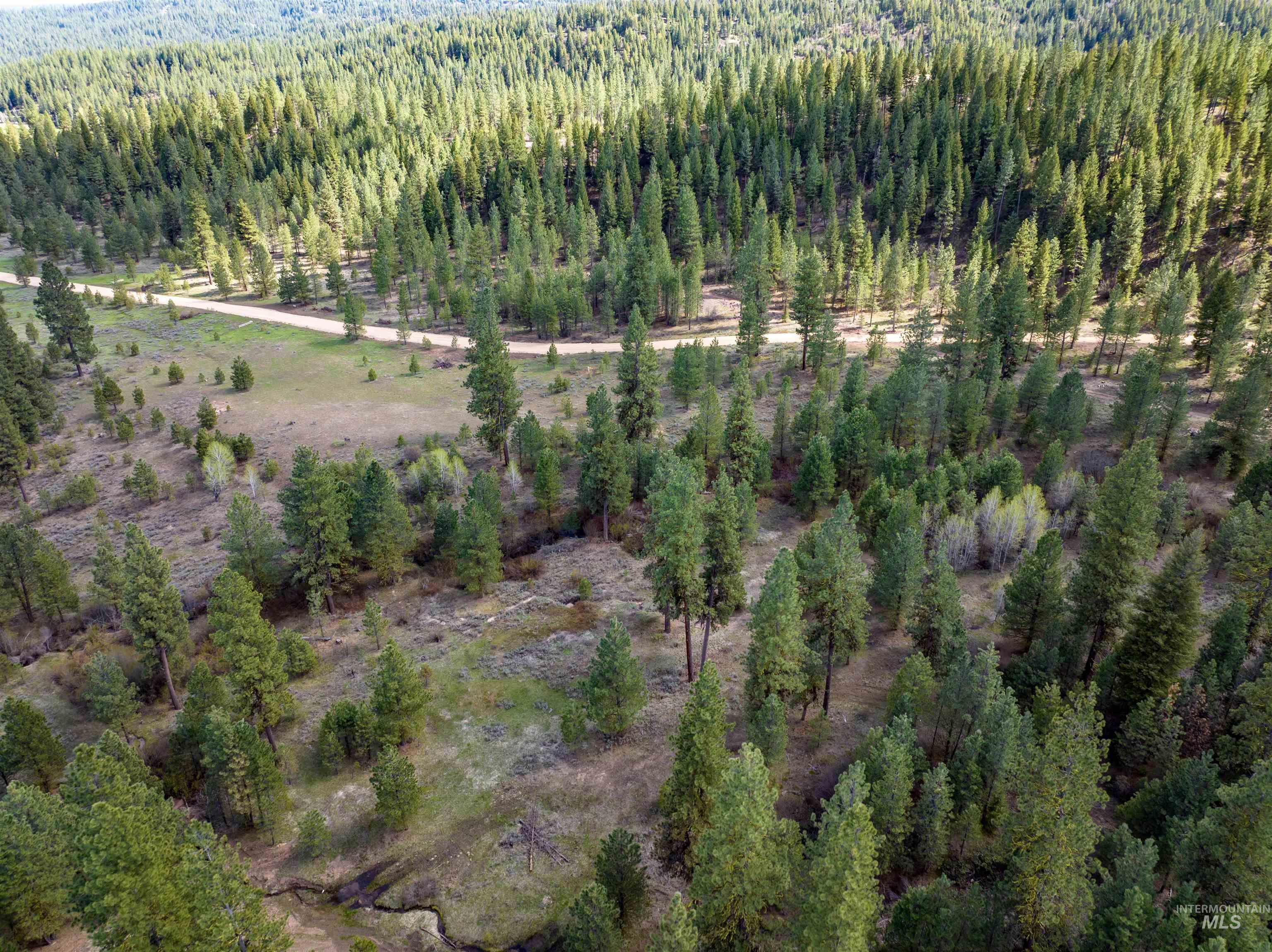 Aerial view of property's location with a heavily wooded area