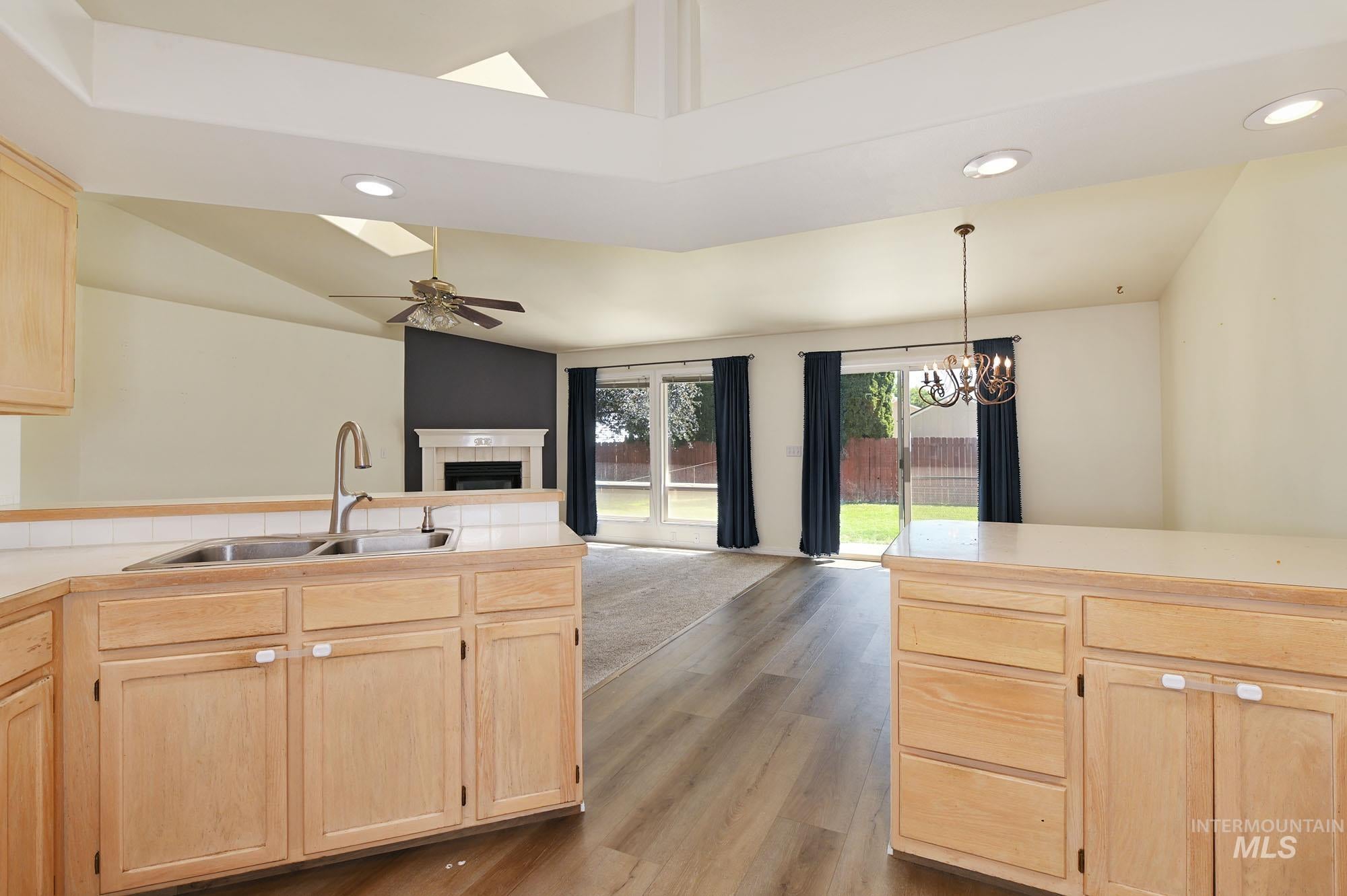 Kitchen with light wood-finish cabinetry and a double basin sink