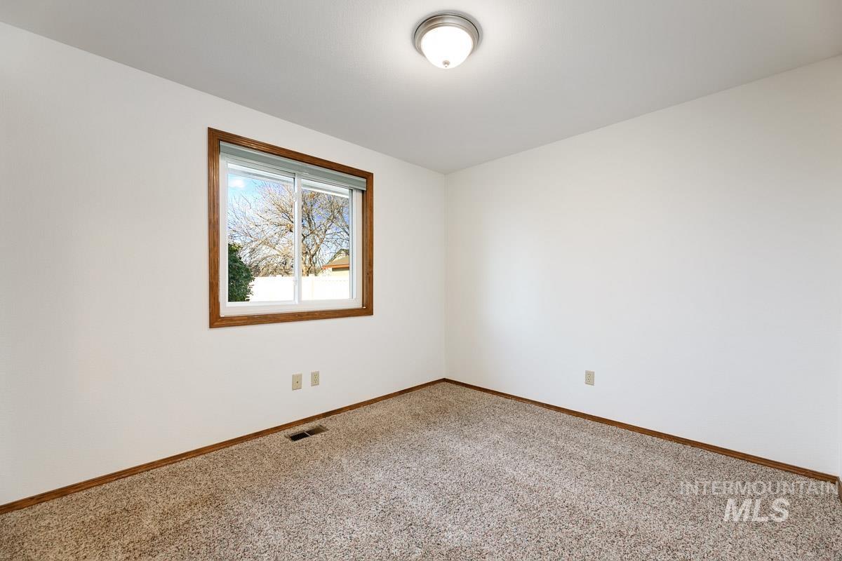 Empty room featuring carpet floors and baseboards