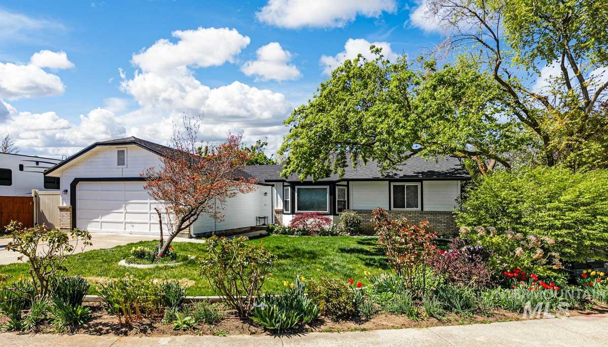 Ranch-style house featuring brick siding, a front lawn, driveway, and a garage