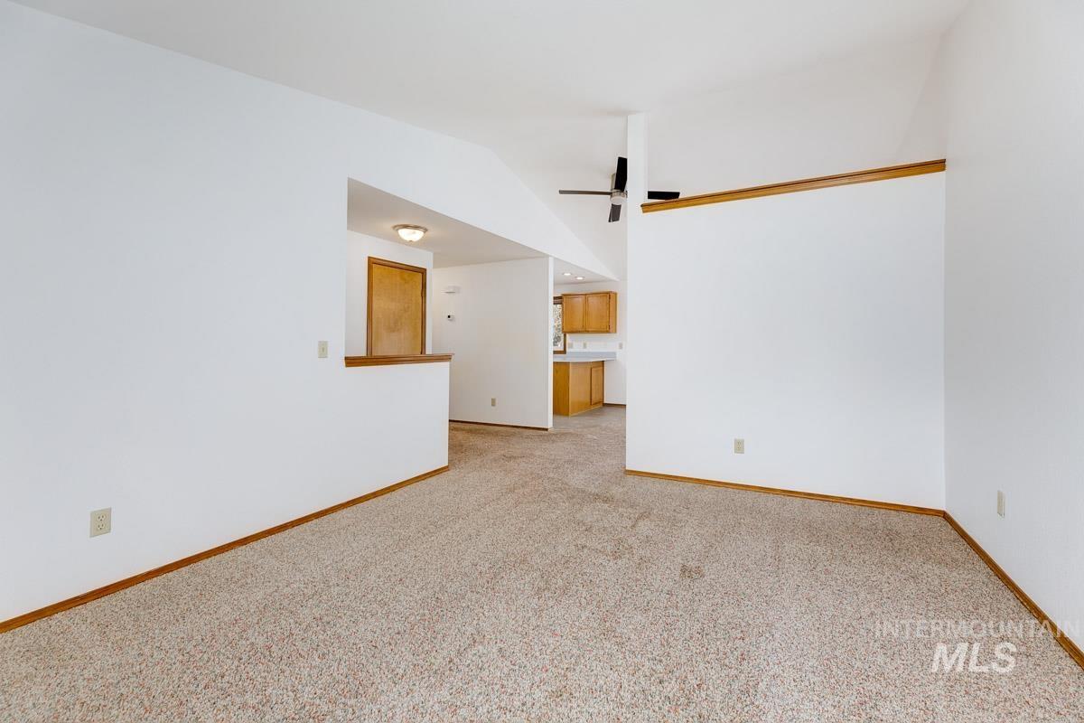 Unfurnished room with light carpet and vaulted ceiling