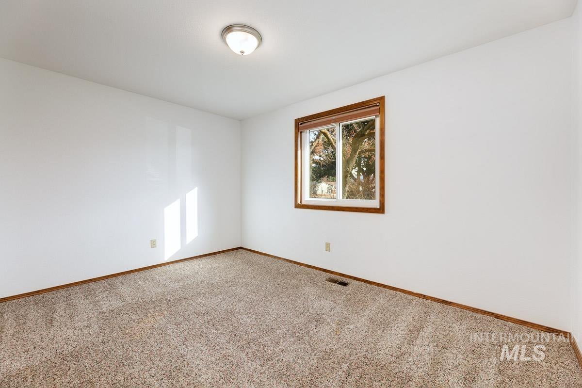 Unfurnished room featuring carpet and baseboards