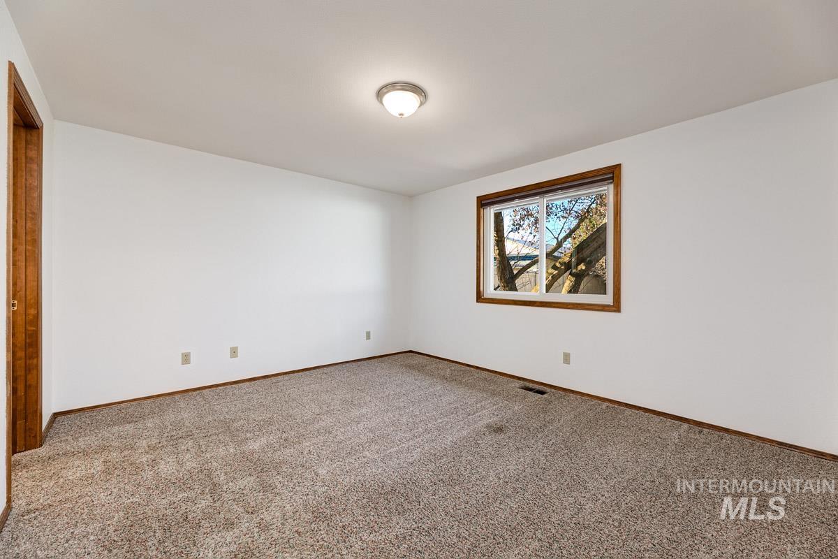 Empty room with carpet and baseboards