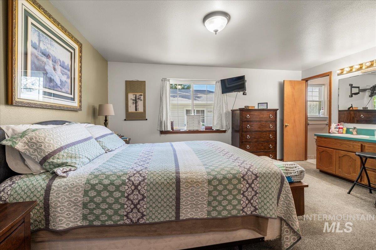 Bedroom featuring light colored carpet and a textured ceiling