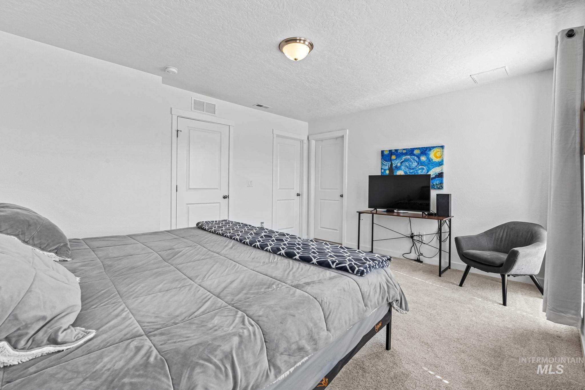 Bedroom featuring carpet and a textured ceiling