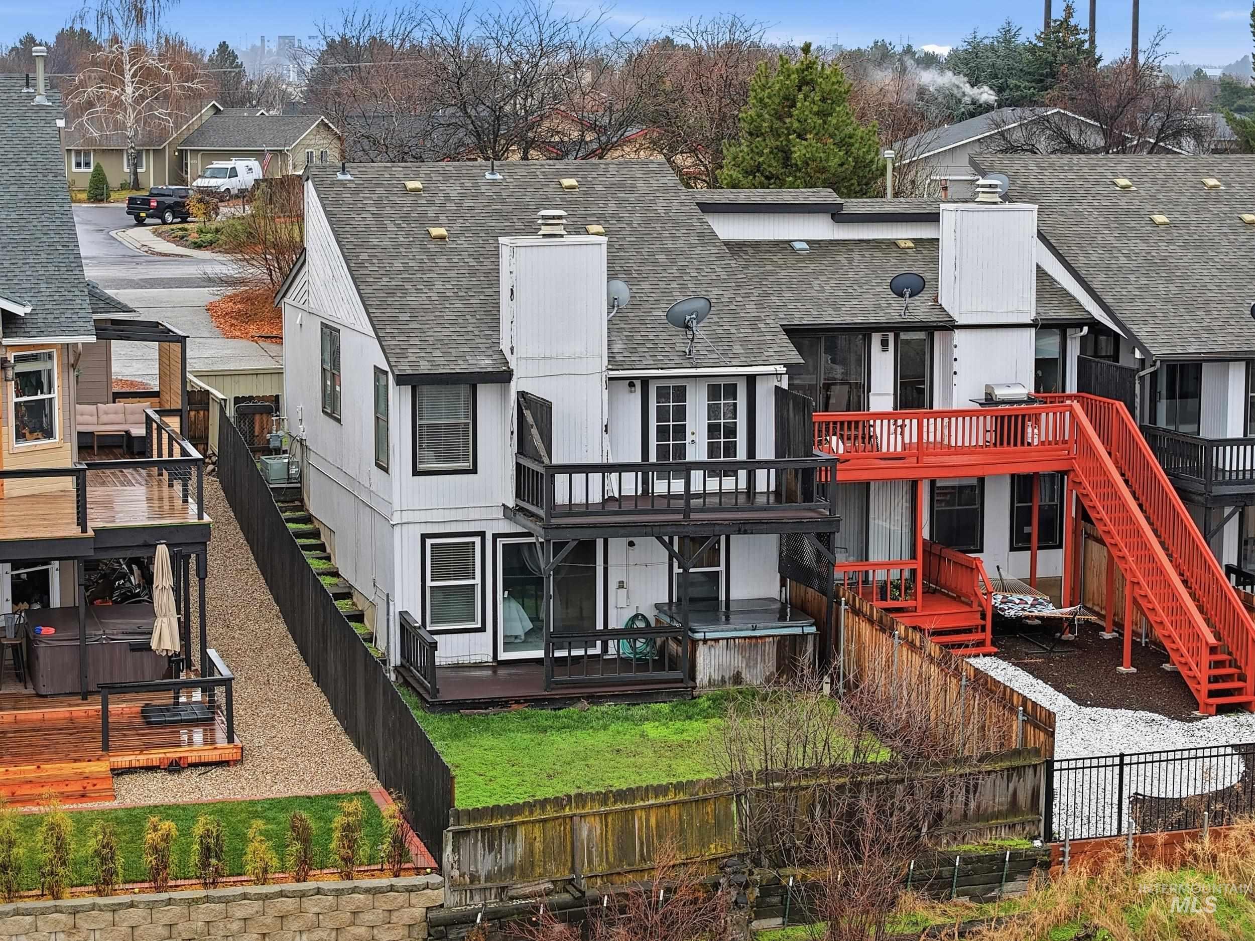 Back of house featuring roof with shingles, a residential view, a fenced backyard, and a deck