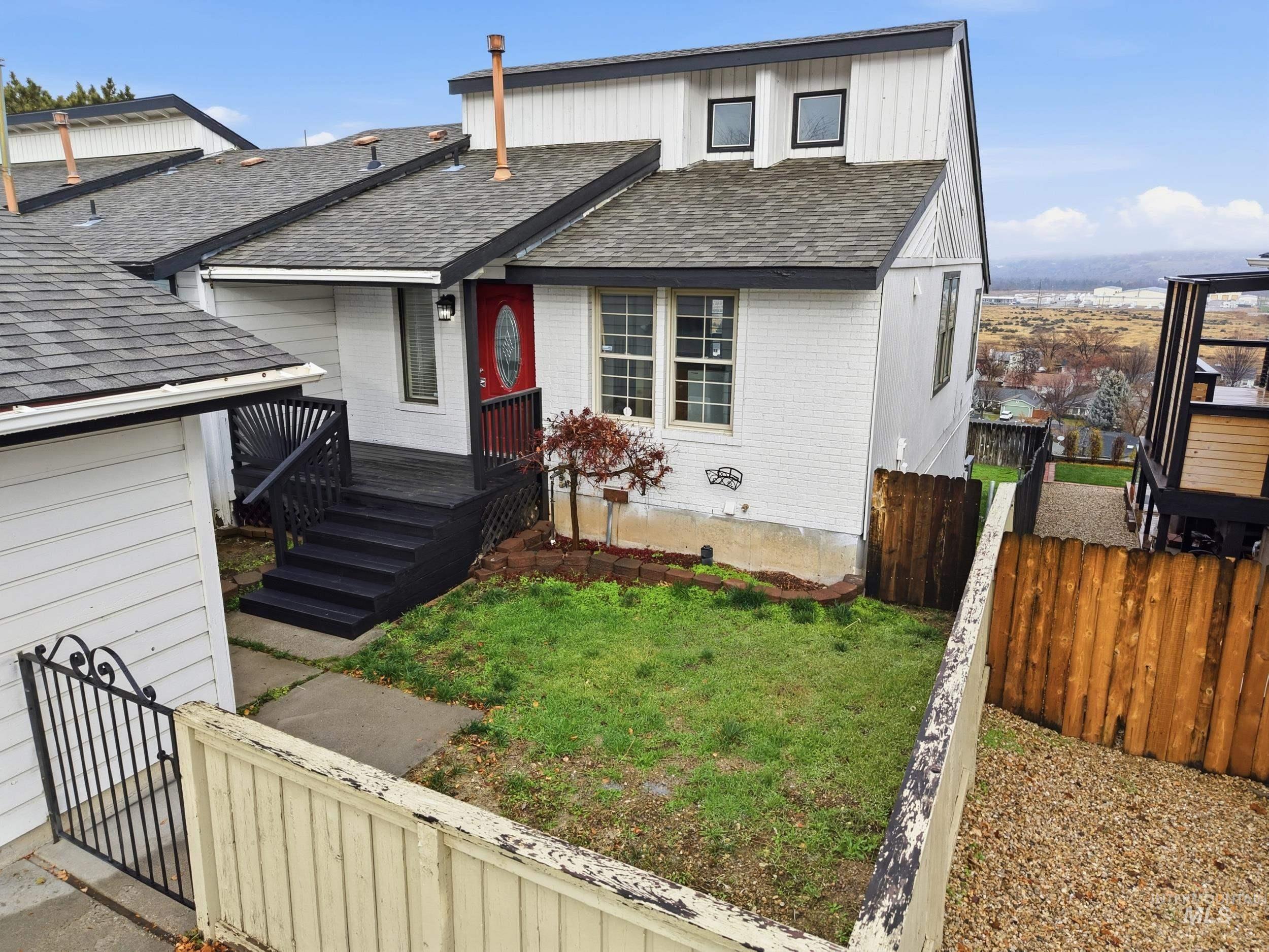 View of front of home with roof with shingles and brick siding