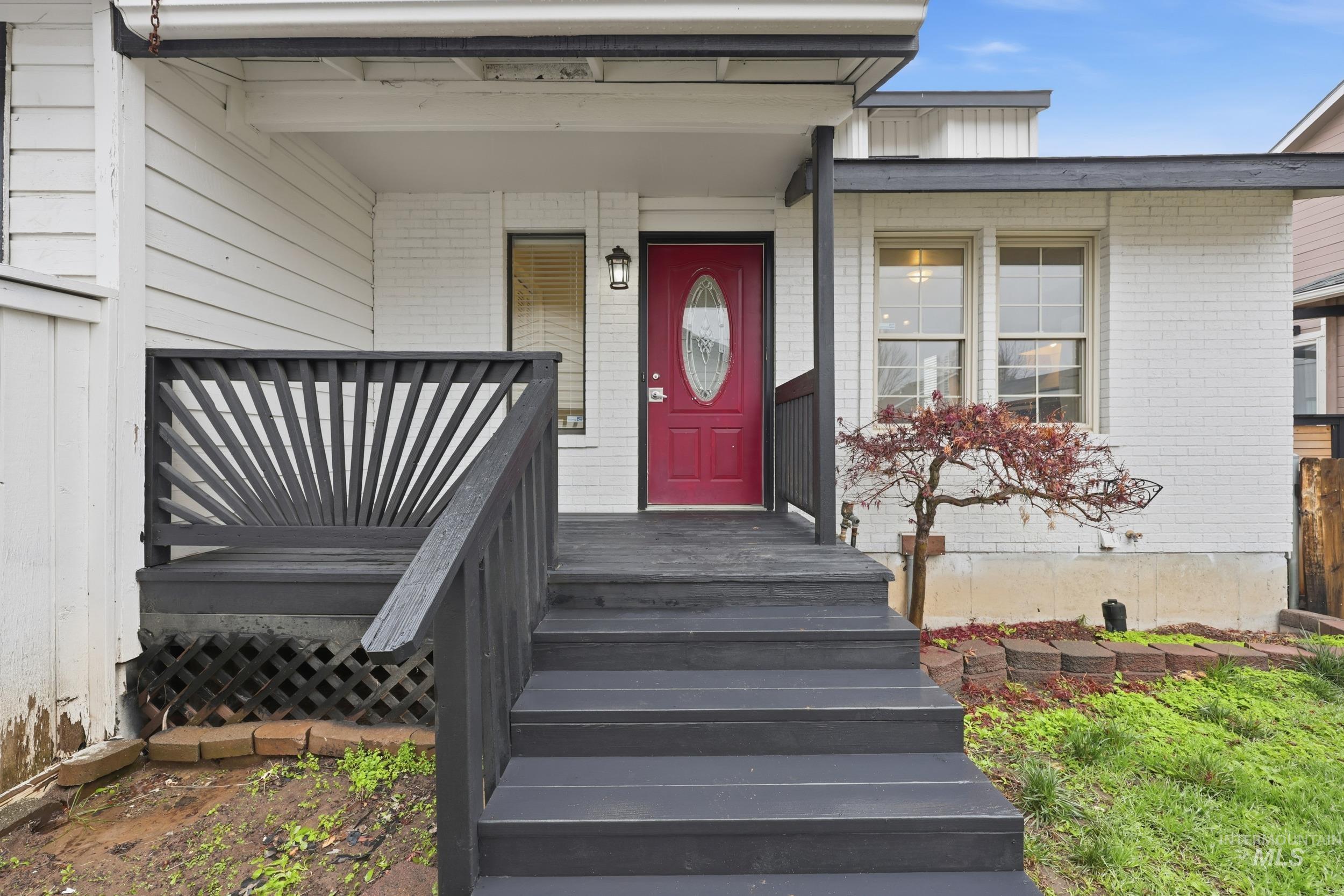 Entrance to property featuring brick siding and a porch