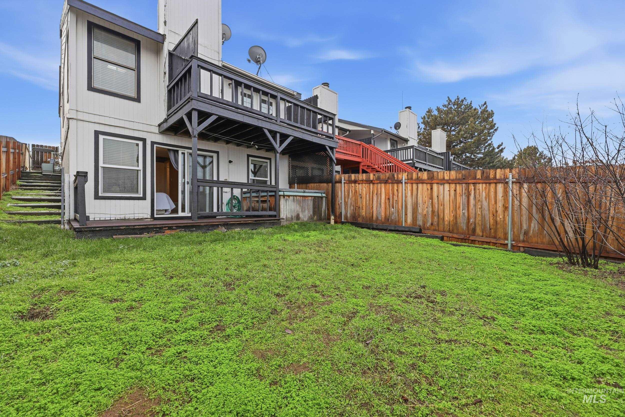 Rear view of property featuring a fenced backyard and a wooden deck