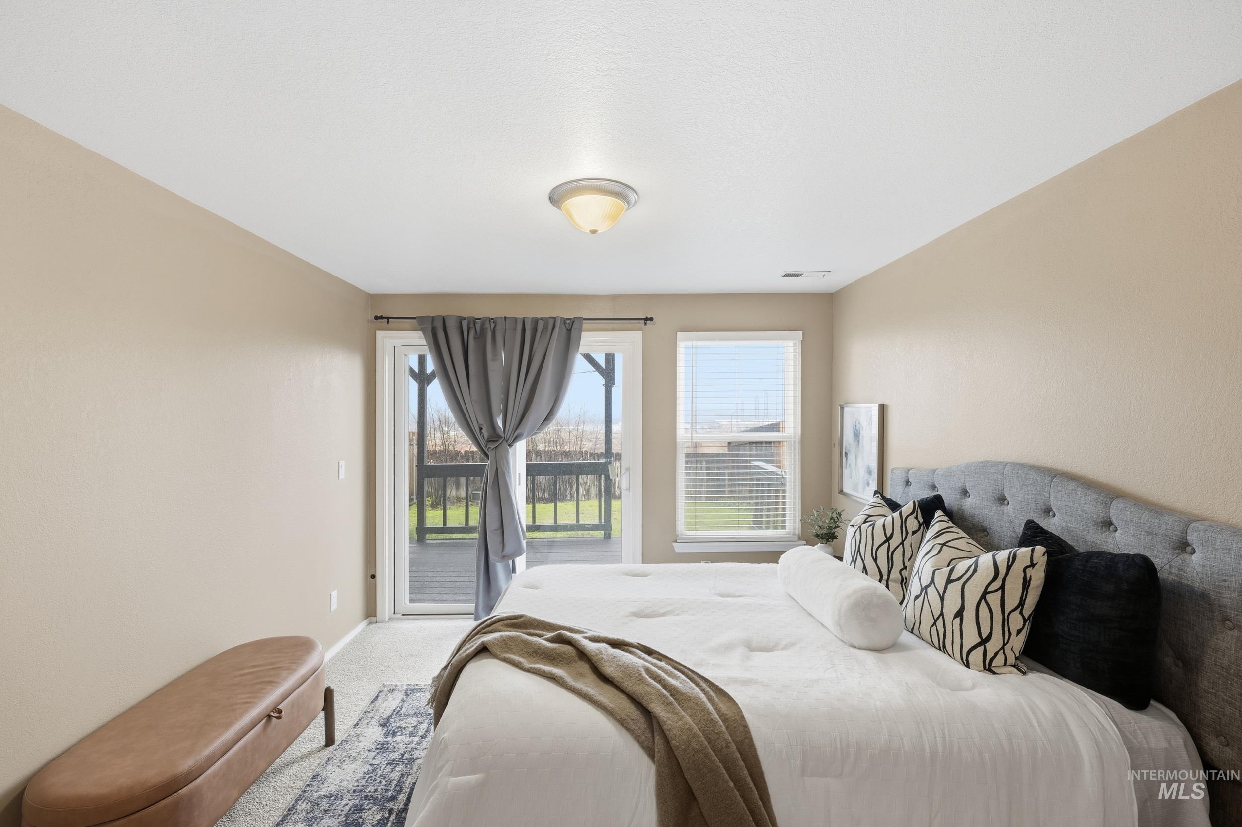 Bedroom featuring access to exterior and light colored carpet