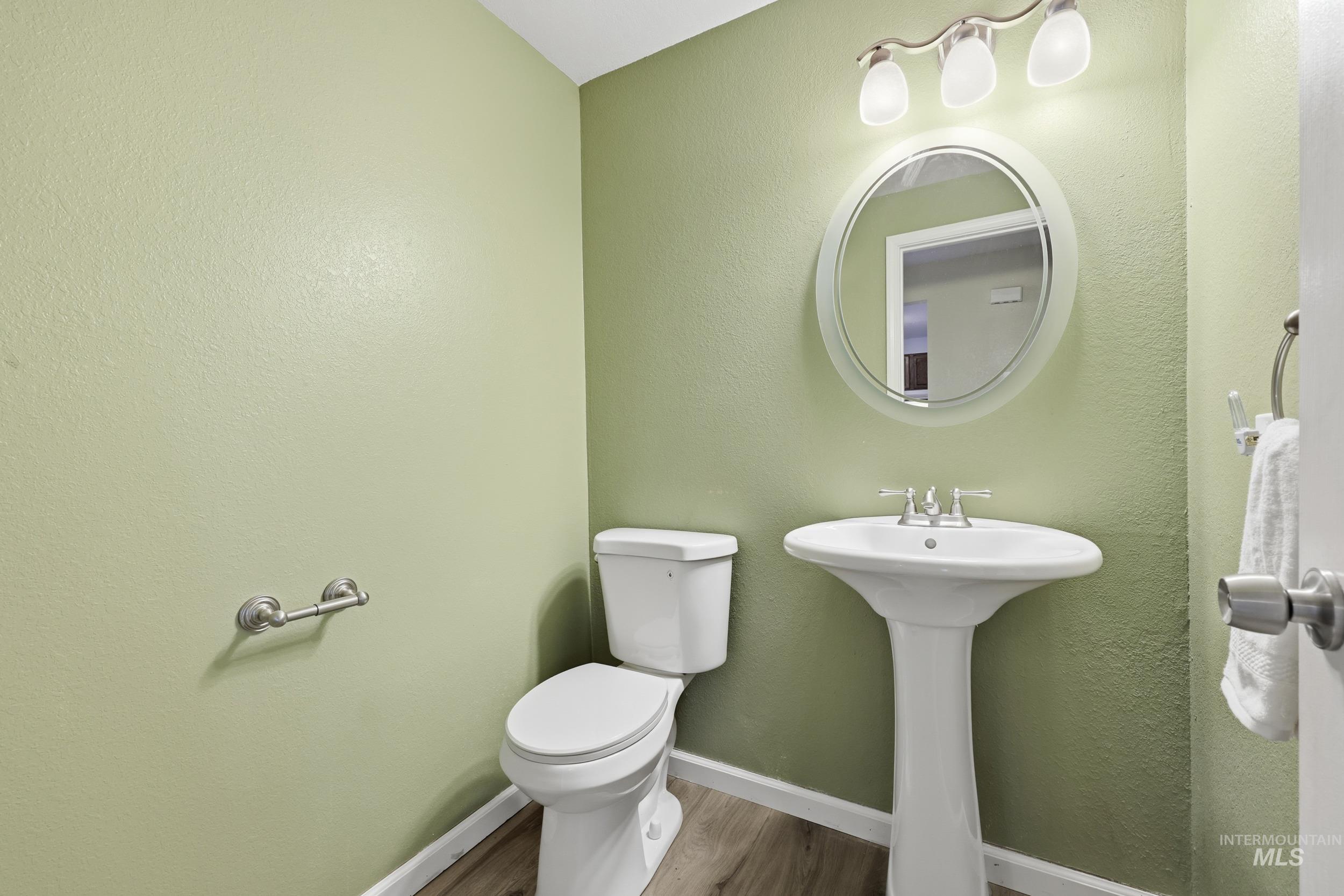 Bathroom featuring a textured wall and wood finished floors