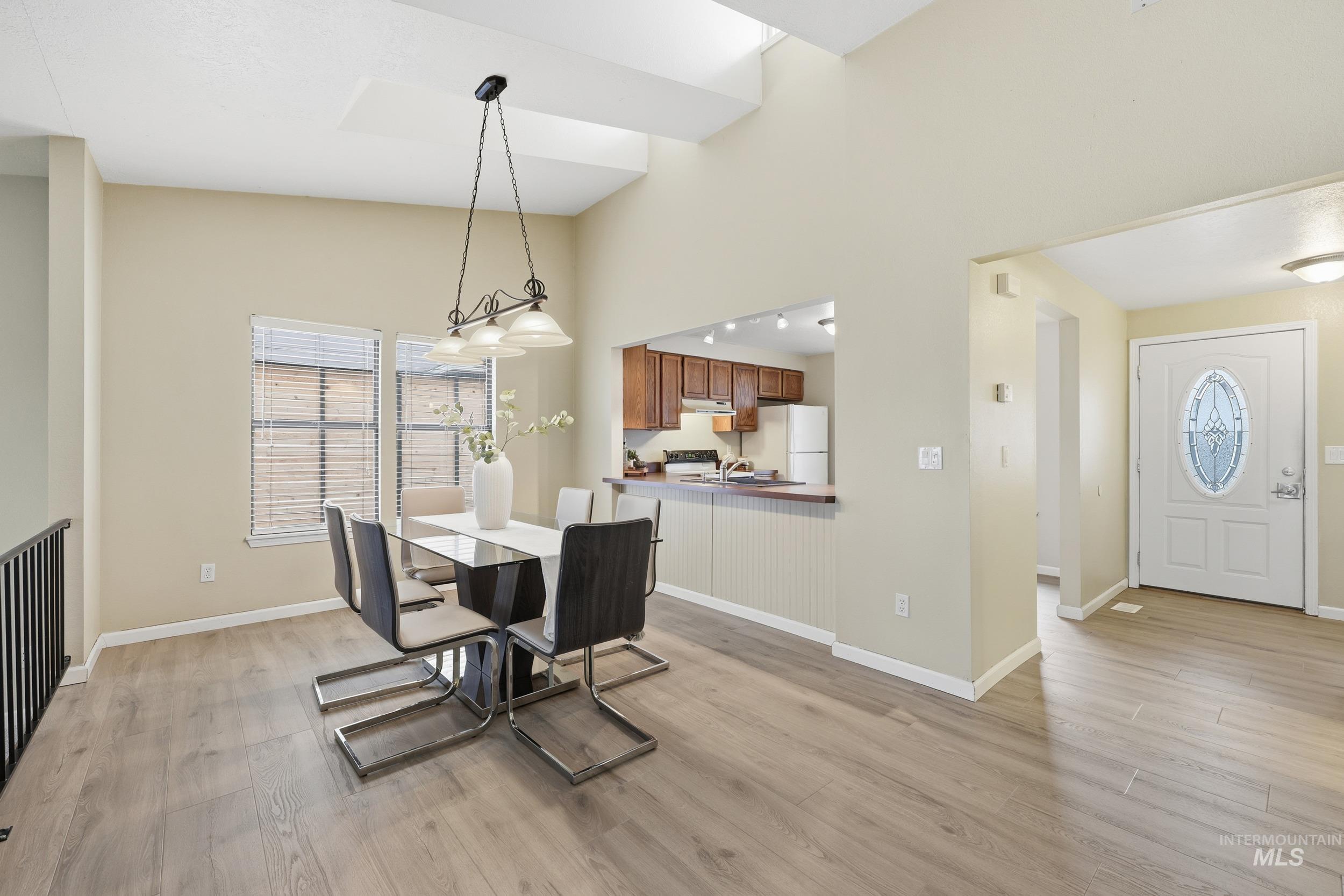 Dining area featuring light wood-type flooring and a high ceiling