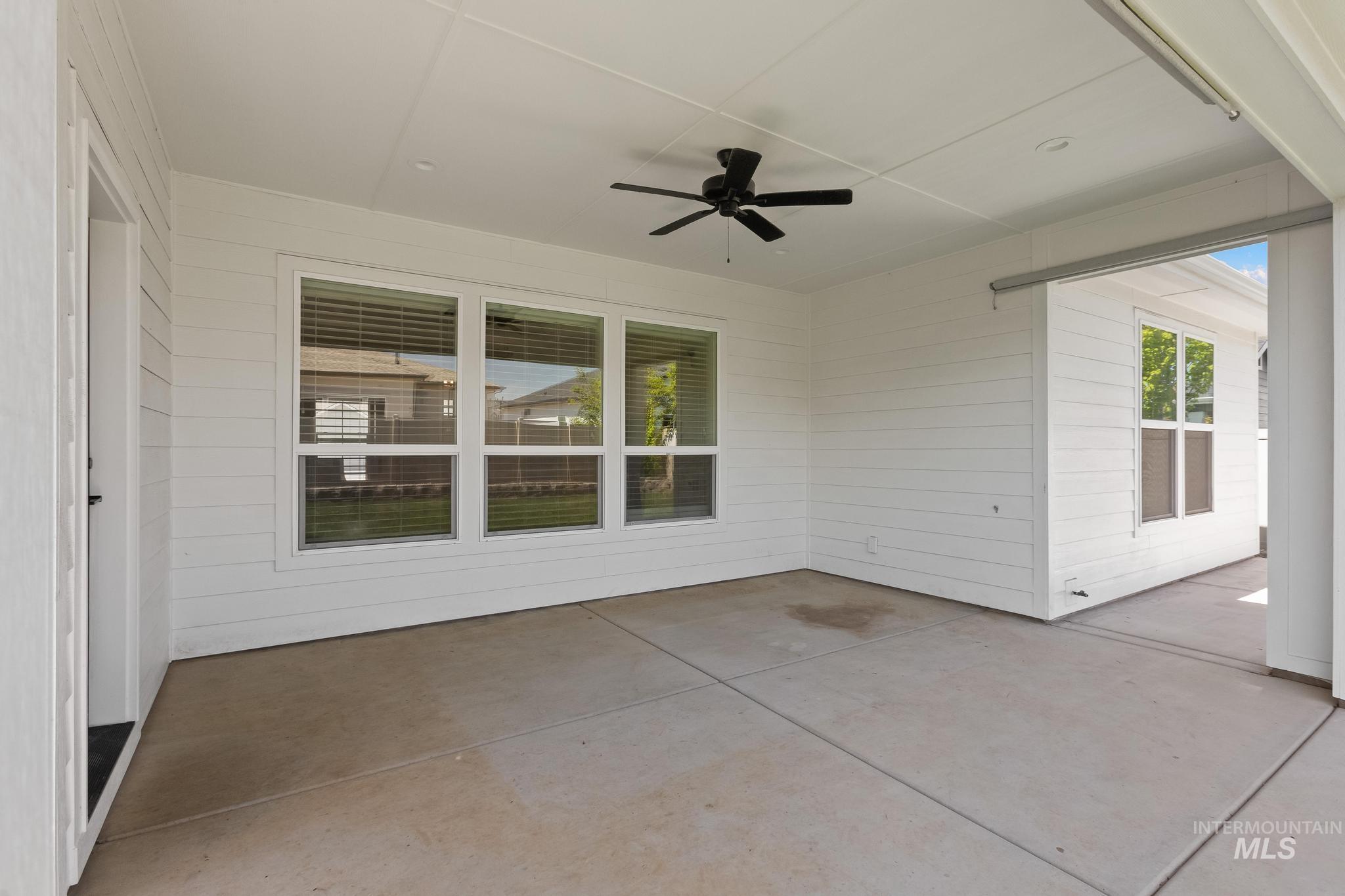 Covered concrete patio featuring a black ceiling fan, recessed lighting, and horizontal siding