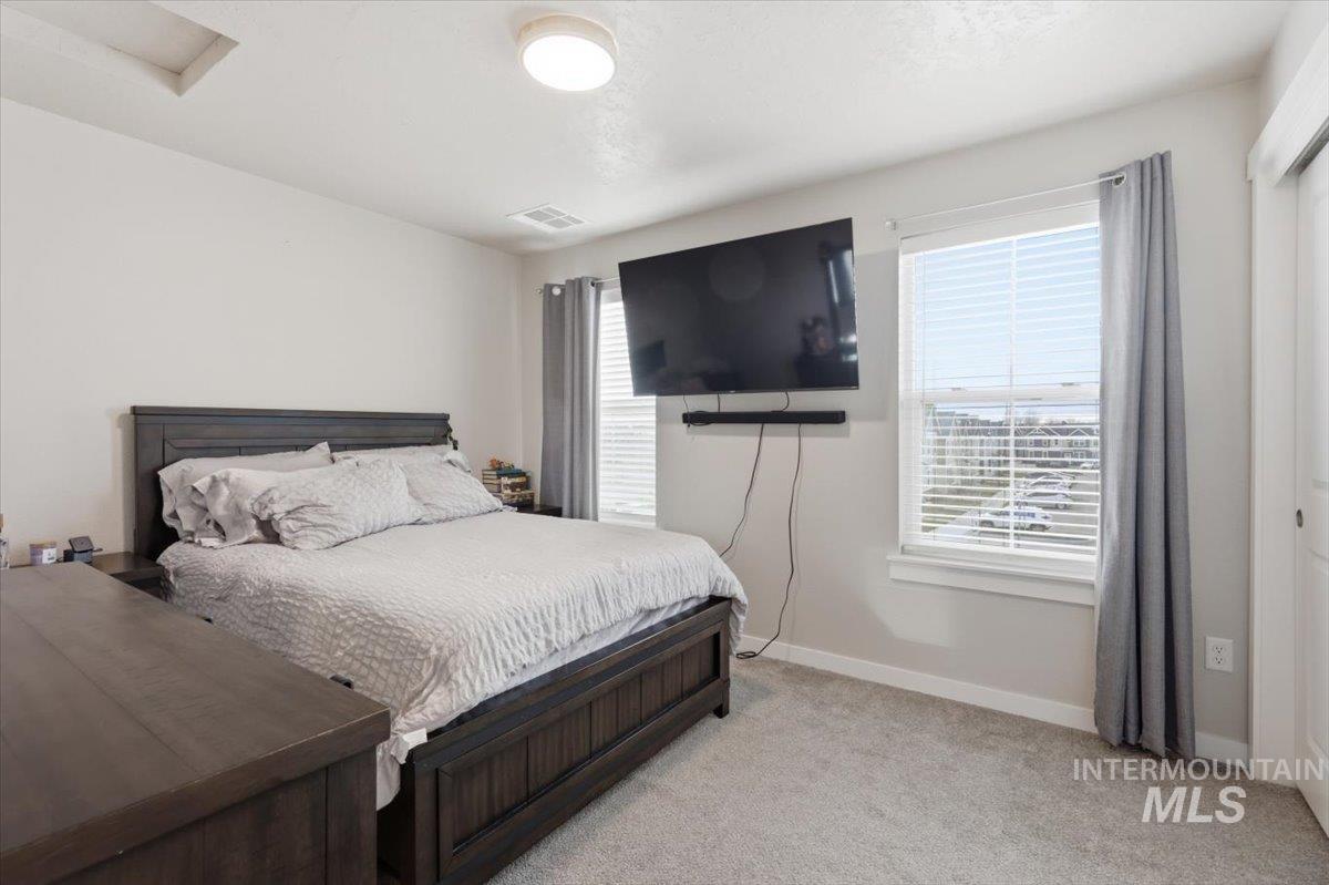 Bedroom featuring baseboards and light colored carpet
