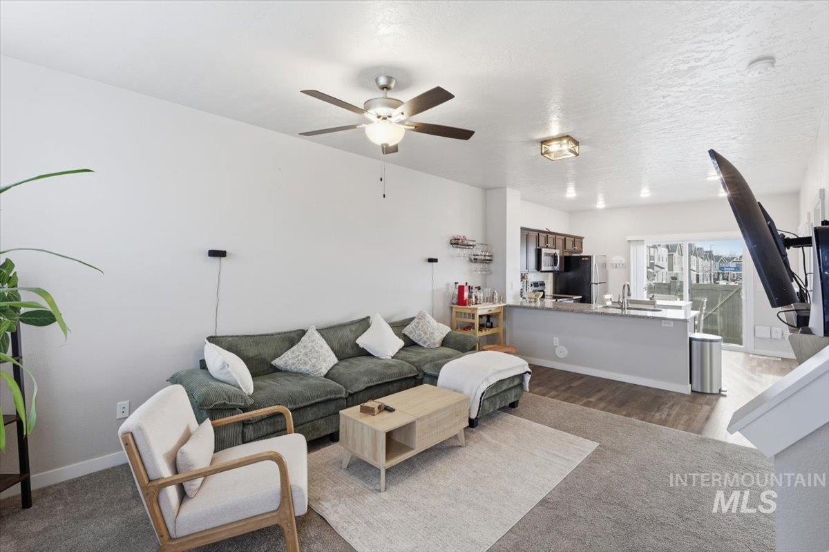 Living area featuring ceiling fan and dark wood finished floors