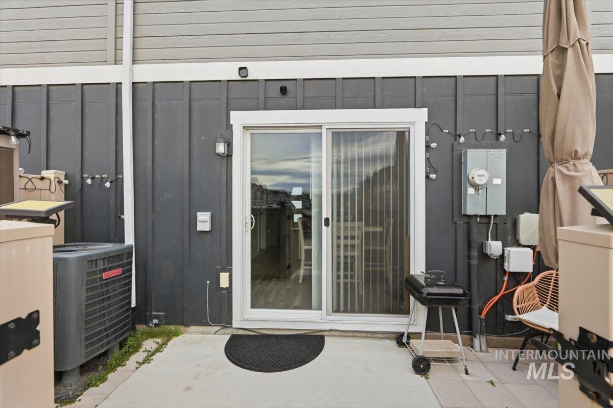 Entrance to property with board and batten siding and a patio area