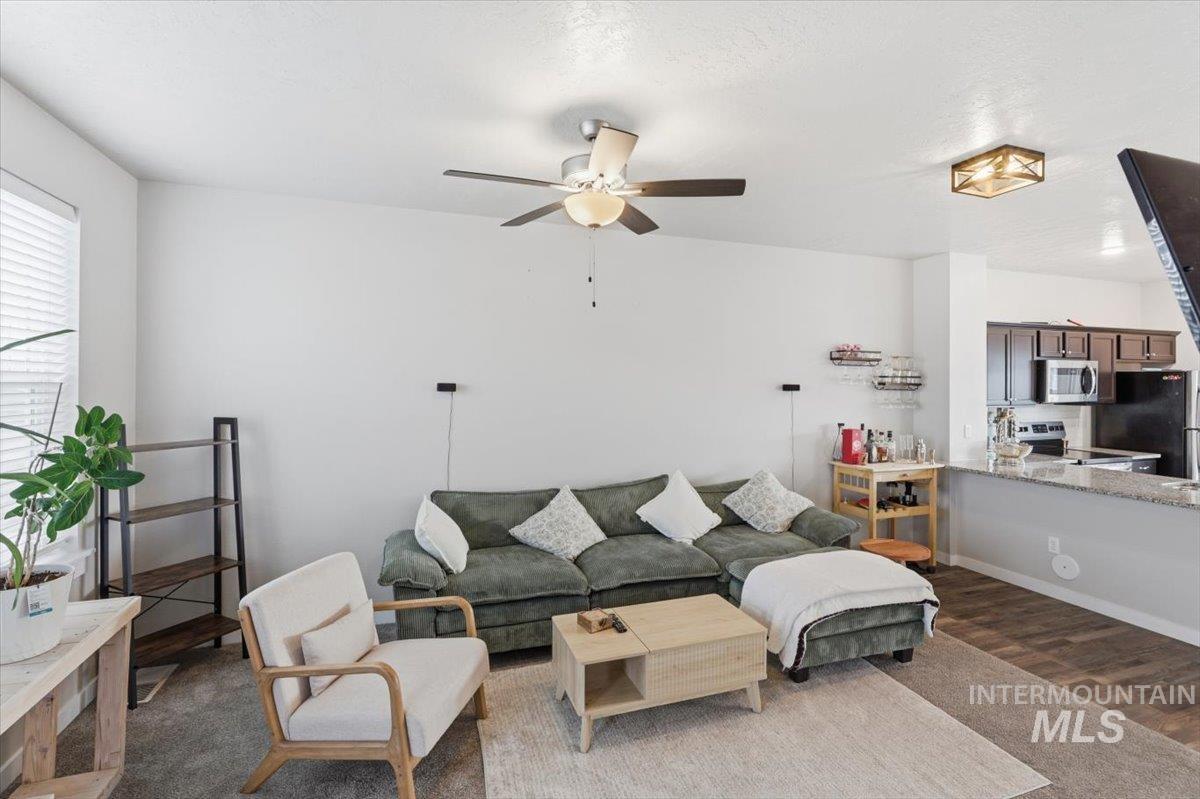 Living area with dark wood-style floors and ceiling fan
