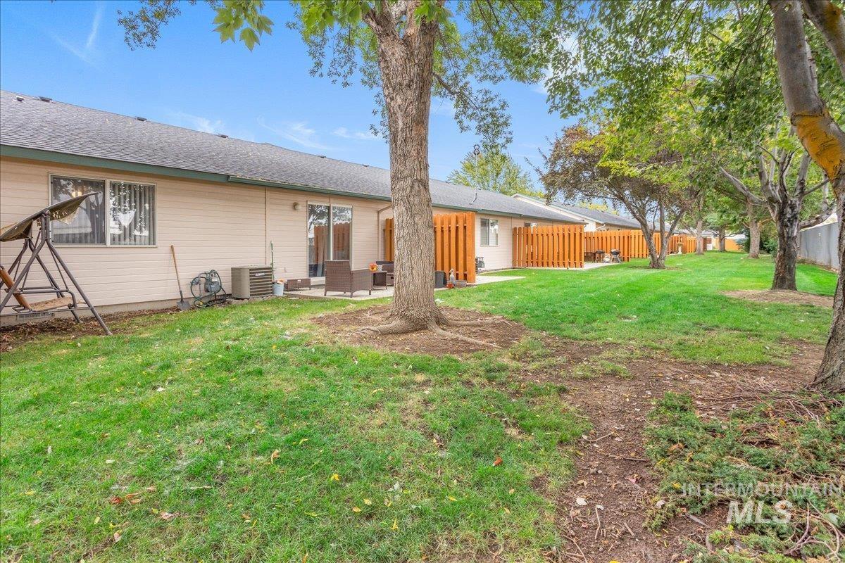 Rear view of house featuring a patio and a shingled roof