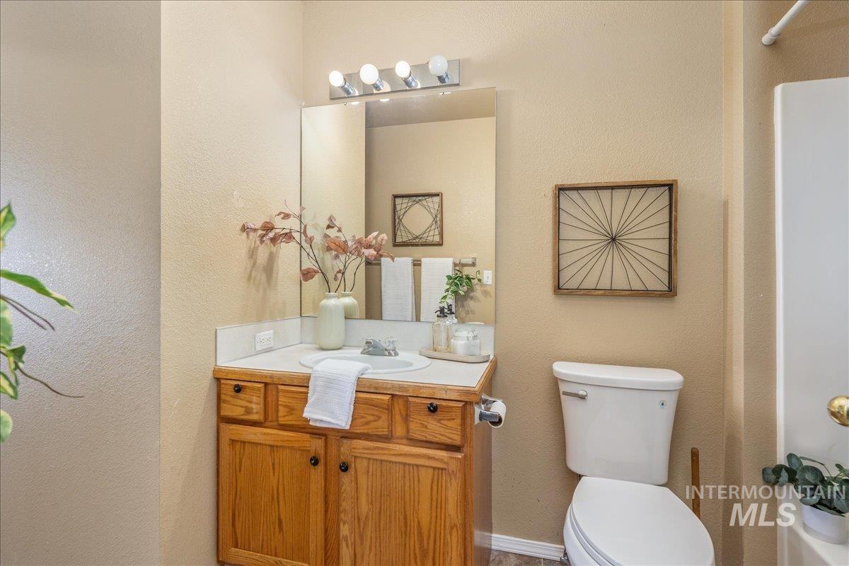 Full bathroom featuring vanity, a textured wall, and shower / bath combo