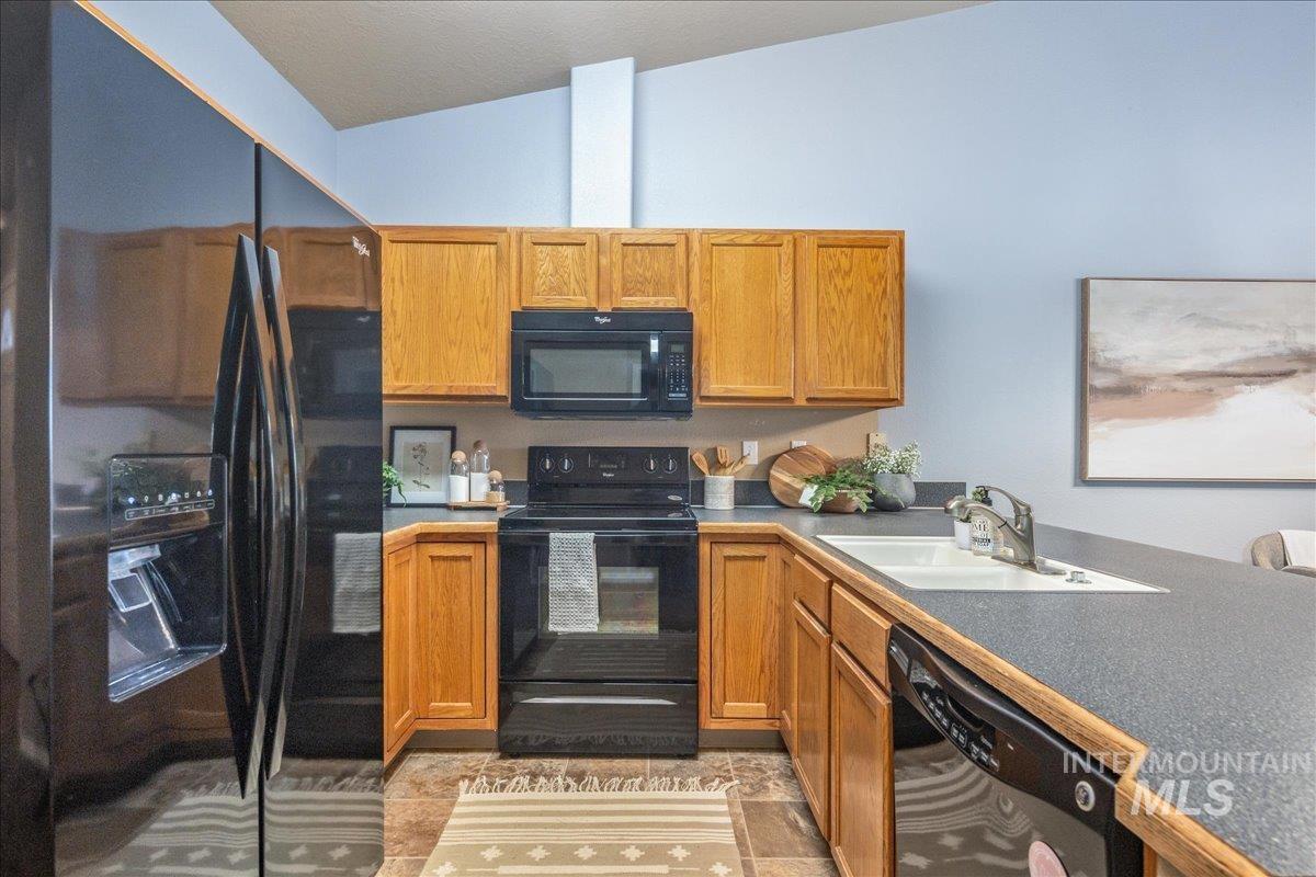 Kitchen featuring black appliances and brown cabinetry