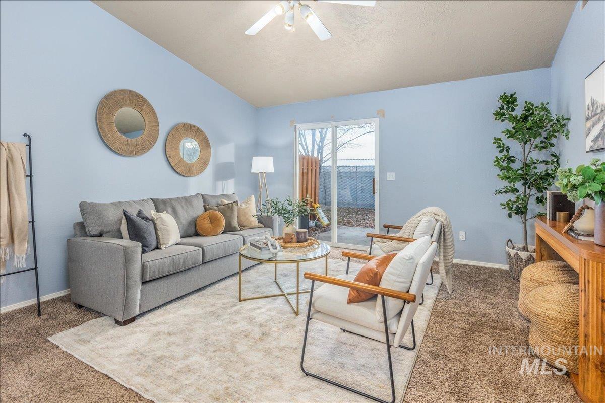Living room with carpet flooring, ceiling fan, and a textured ceiling