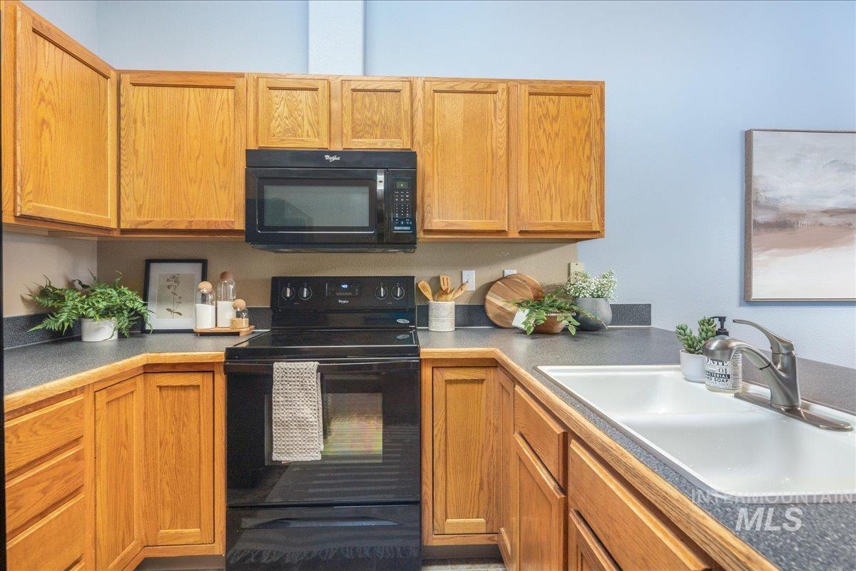 Kitchen with black appliances and brown cabinetry