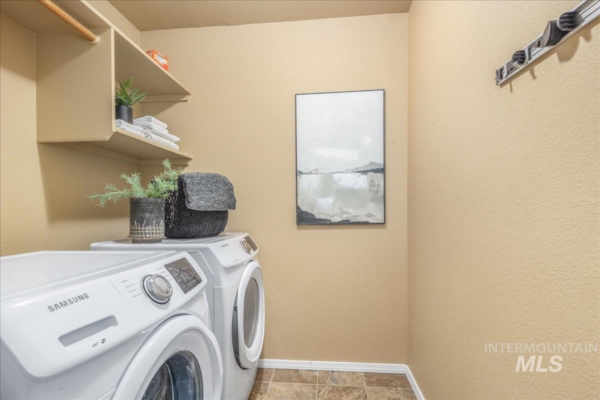 Washroom with washer and clothes dryer and baseboards
