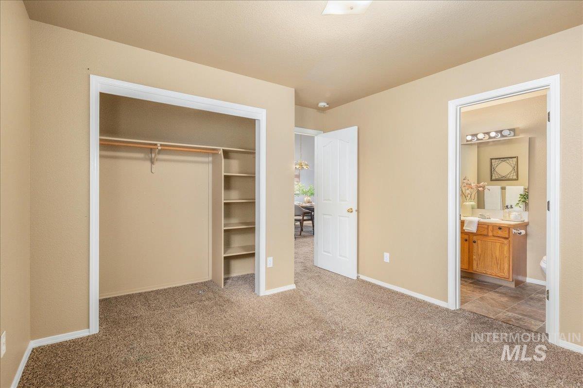 Unfurnished bedroom featuring carpet floors, a closet, and connected bathroom