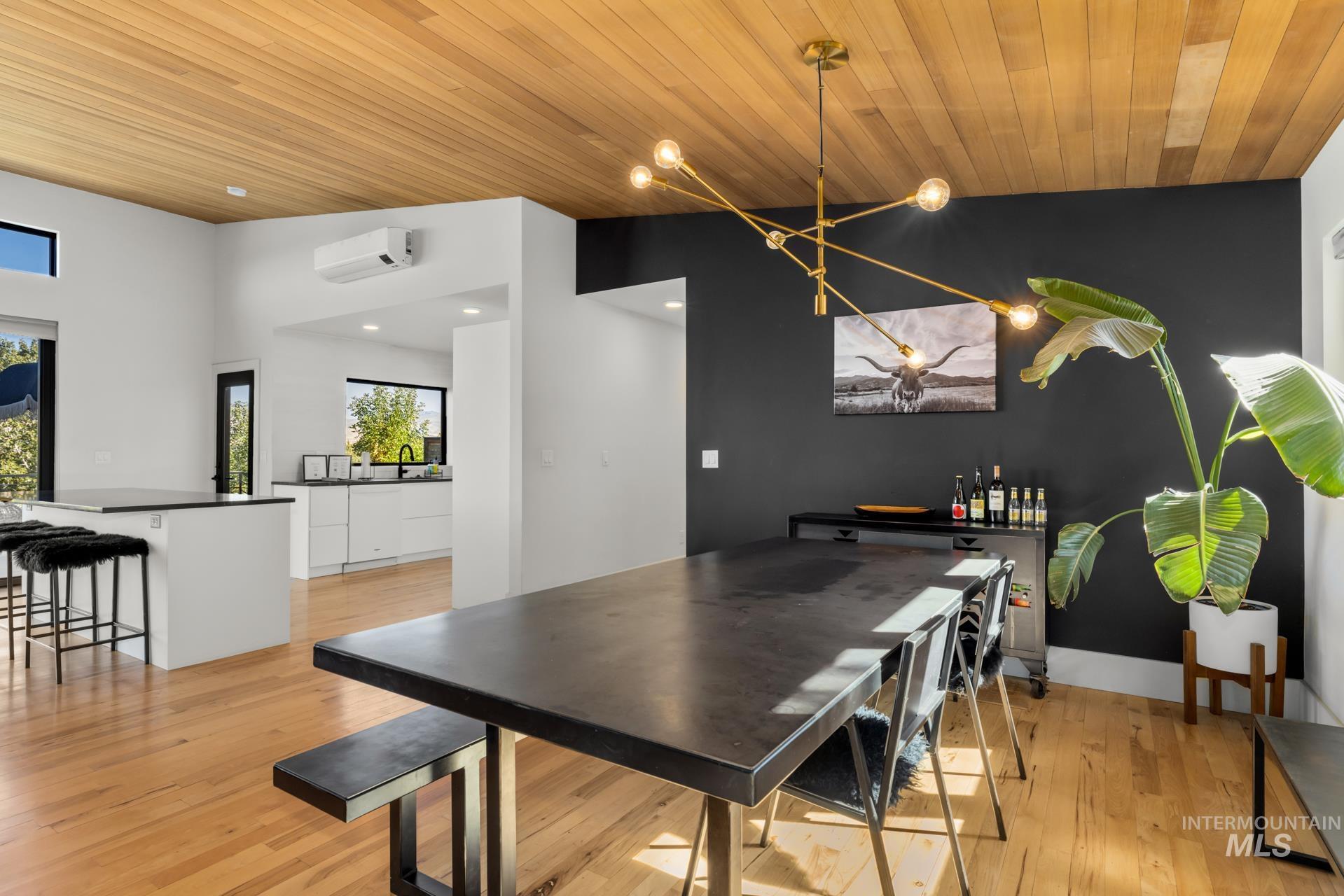 Dining space with light wood finished floors, wood ceiling, a chandelier, and recessed lighting