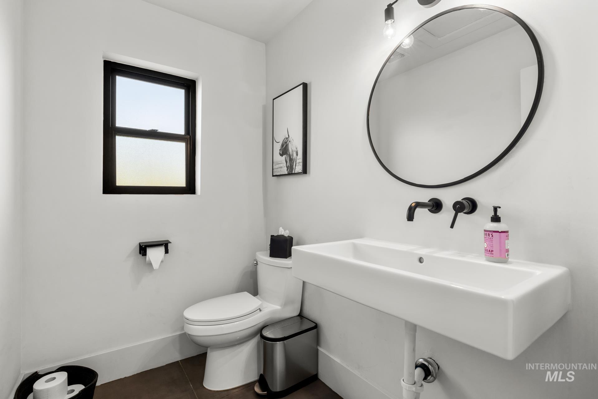 Half bathroom featuring toilet and dark tile patterned flooring