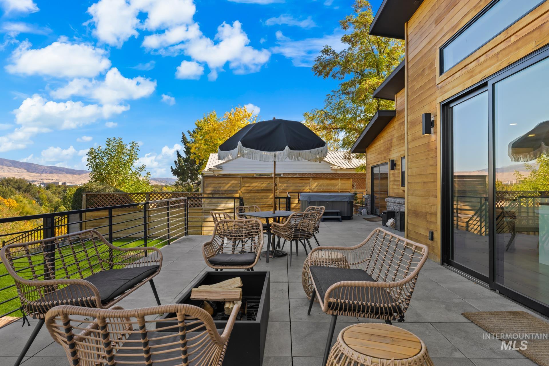 View of patio / terrace with a hot tub and outdoor dining area