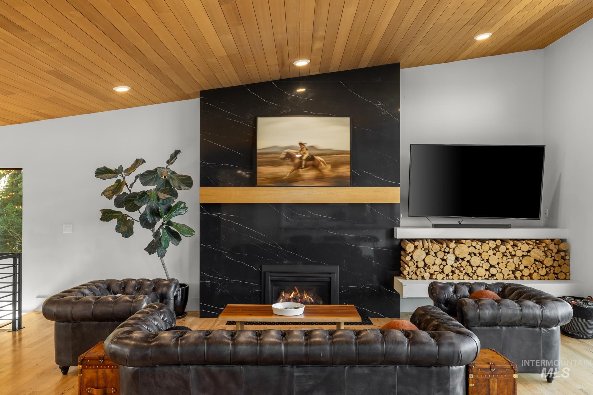 Living area featuring wood finished floors, a fireplace, recessed lighting, and wooden ceiling